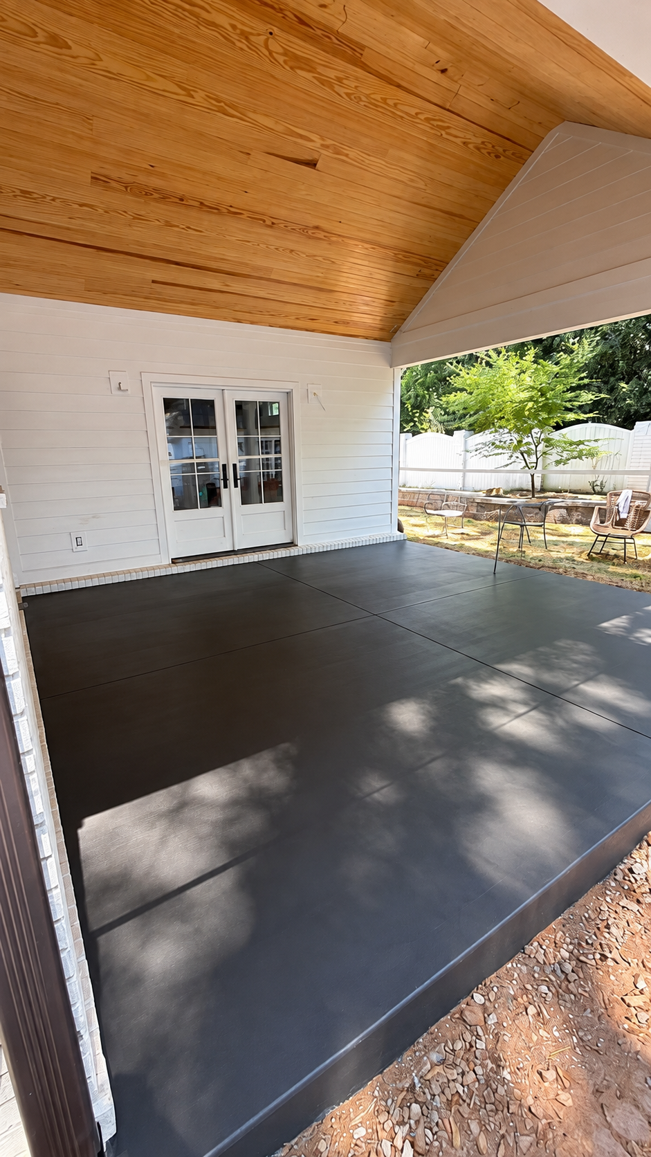 Dark finished concrete patio under a wood roof